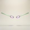 Two glass straws with pink oval tips on a beige background