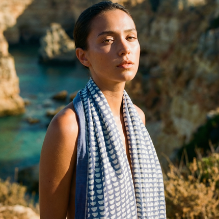 Blue lightweight cotton block print scarf worn by model coastal setting / Foulard léger en coton bleu imprimé bloc porté en bord de mer