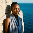 Blue lightweight cotton block print scarf worn by model coastal setting / Foulard léger en coton bleu imprimé bloc porté en bord de mer