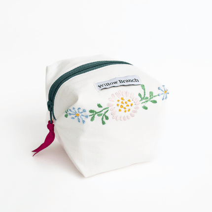 Handmade white boxy makeup bag with hand-embroidered flowers and teal zipper, Montreal artisan Willow Branch / Trousse boxy blanche faite main avec broderies florales et fermeture éclair sarcelle, artisane montréalaise Willow Branch