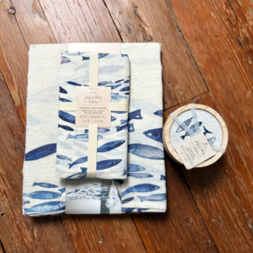 Set of folded towels with blue fish pattern on a wooden surface
