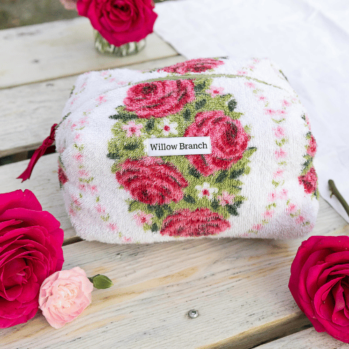 Floral-patterned product with 'Willow Branch' label on a wooden surface with roses.