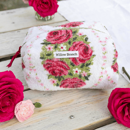 Floral-patterned product with 'Willow Branch' label on a wooden surface with roses.